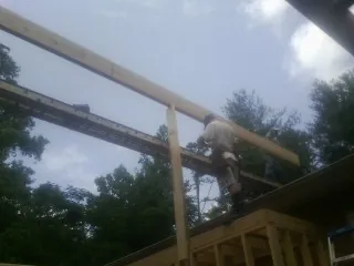 Carpenter setting a ridge beam over a new addition frame — Ice Dam Removal by Roofing Brothers in Cleveland
